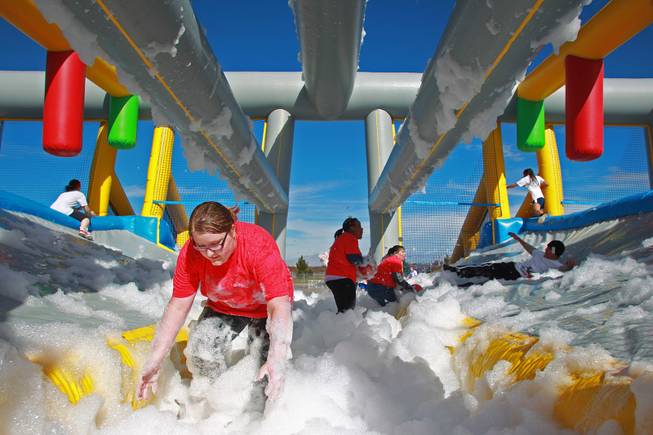 Volunteers search in suds for balls to throw at participants navigating an obstacle during the Hit and Run 5k Saturday, March 1, 2014 at Sam Boyd Stadium. The Hit and Run 5k, a fun run with various obstacles throughout the course, is being held or planned in two dozen cities across the country.